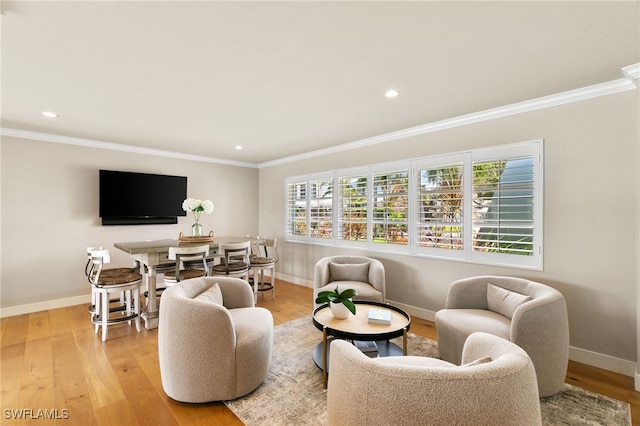 living room featuring plenty of natural light, crown molding, and light hardwood / wood-style flooring