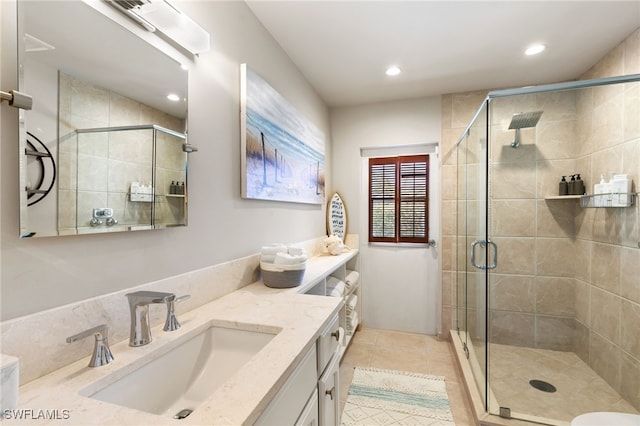 bathroom with tile patterned flooring, vanity, and an enclosed shower