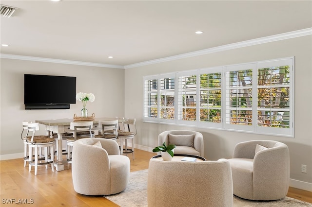 living area featuring light hardwood / wood-style floors and crown molding