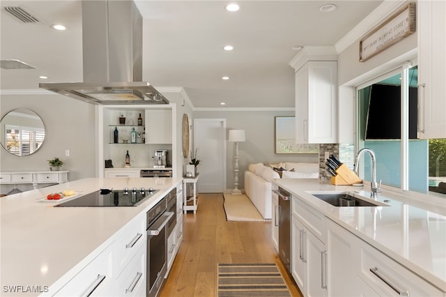 kitchen featuring sink, light hardwood / wood-style flooring, island range hood, white cabinets, and appliances with stainless steel finishes