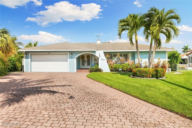 single story home featuring french doors, a front lawn, and a garage