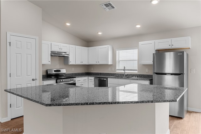 kitchen with appliances with stainless steel finishes, sink, a kitchen island, vaulted ceiling, and white cabinets