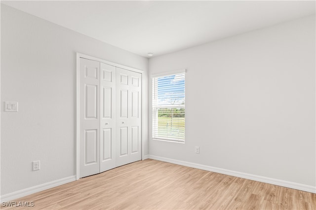 unfurnished bedroom featuring light hardwood / wood-style floors and a closet