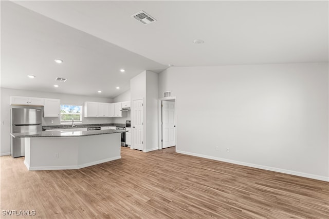 kitchen with appliances with stainless steel finishes, sink, light hardwood / wood-style flooring, a center island, and white cabinetry