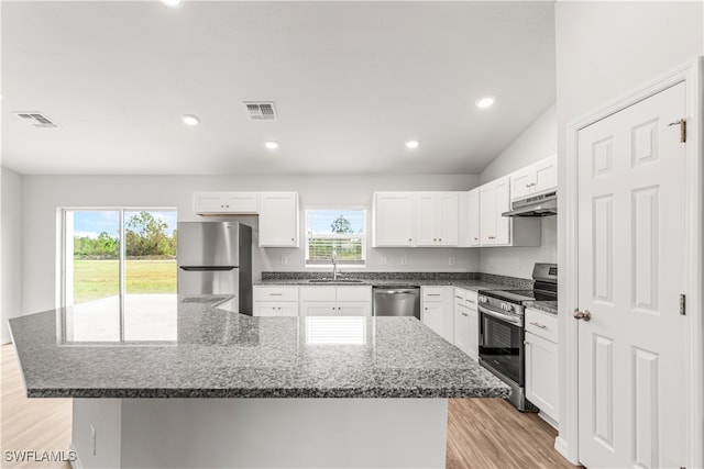 kitchen with stainless steel appliances, white cabinetry, a wealth of natural light, and light hardwood / wood-style flooring