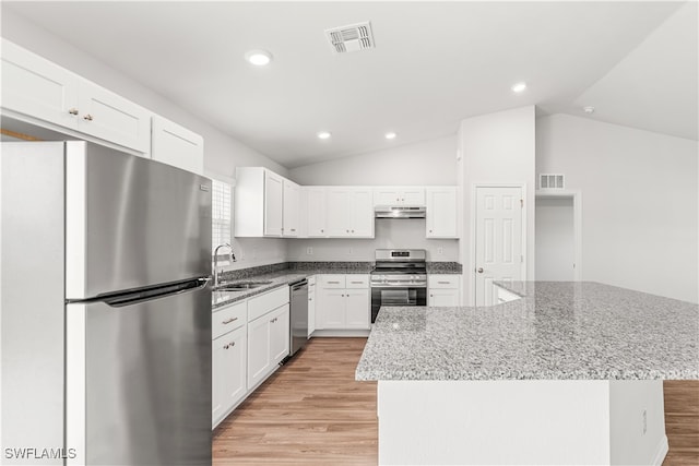 kitchen featuring white cabinets, stainless steel appliances, vaulted ceiling, and a kitchen island