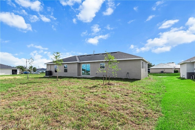 rear view of house with a lawn and cooling unit