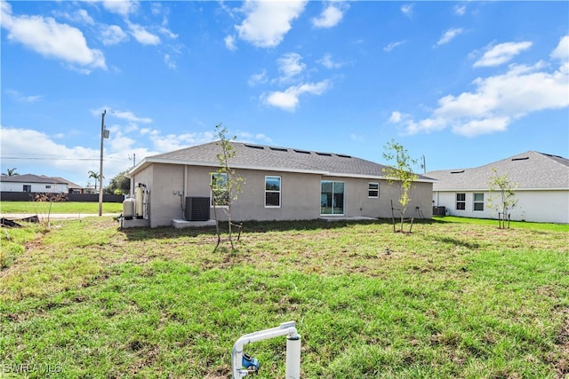 back of property with a lawn and central AC unit