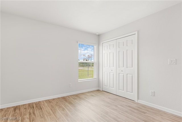 unfurnished bedroom with light hardwood / wood-style floors and a closet