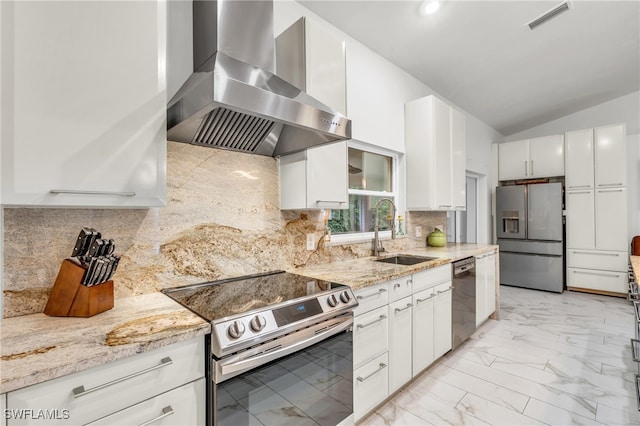 kitchen featuring appliances with stainless steel finishes, decorative backsplash, white cabinets, wall chimney exhaust hood, and sink