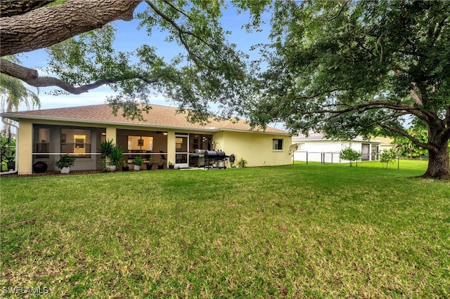 view of front of house with a sunroom and a front lawn