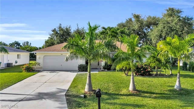 view of front of home featuring a front yard, a garage, and central AC