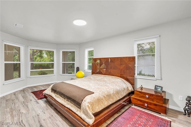 bedroom featuring light hardwood / wood-style flooring and multiple windows