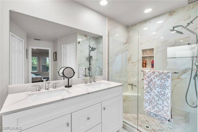 bathroom featuring a shower with door and vanity