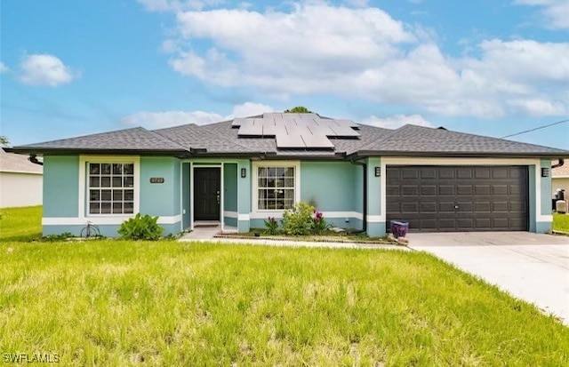 ranch-style house featuring a front lawn, solar panels, and a garage