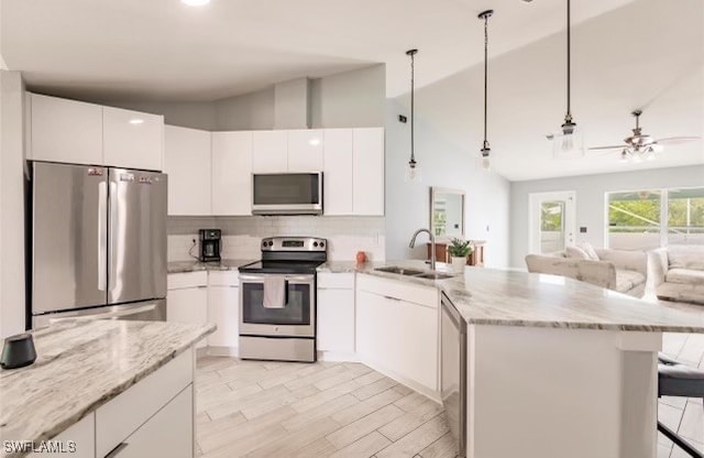 kitchen featuring ceiling fan, lofted ceiling, sink, white cabinetry, and stainless steel appliances