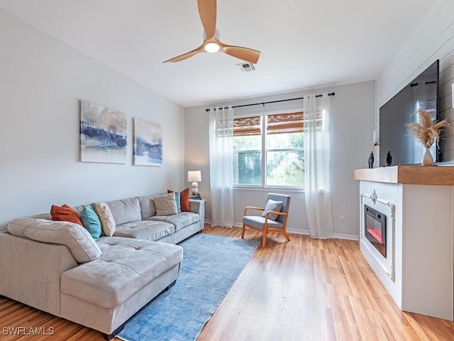 living room with ceiling fan and light hardwood / wood-style flooring