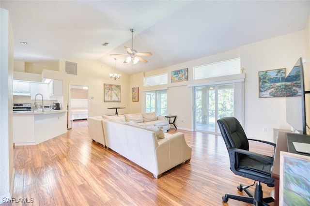 living room featuring lofted ceiling, sink, ceiling fan with notable chandelier, and light hardwood / wood-style floors