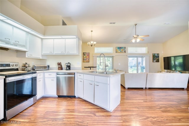 kitchen with pendant lighting, sink, white cabinets, kitchen peninsula, and stainless steel appliances