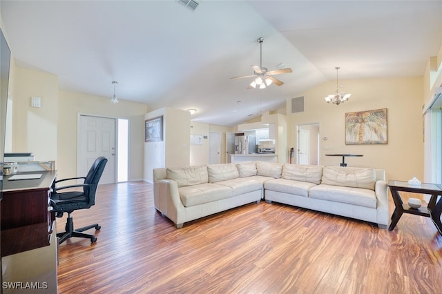 living room with ceiling fan with notable chandelier, lofted ceiling, and hardwood / wood-style floors