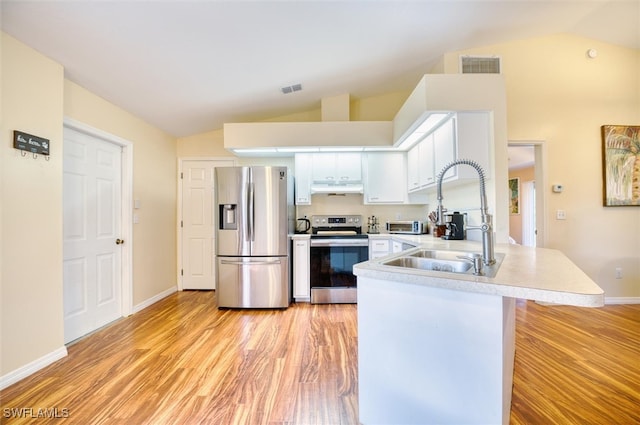 kitchen with appliances with stainless steel finishes, sink, lofted ceiling, and kitchen peninsula