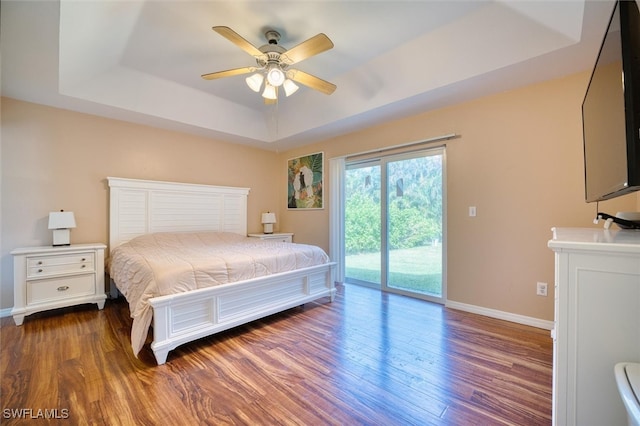 bedroom with access to exterior, wood-type flooring, a raised ceiling, and ceiling fan