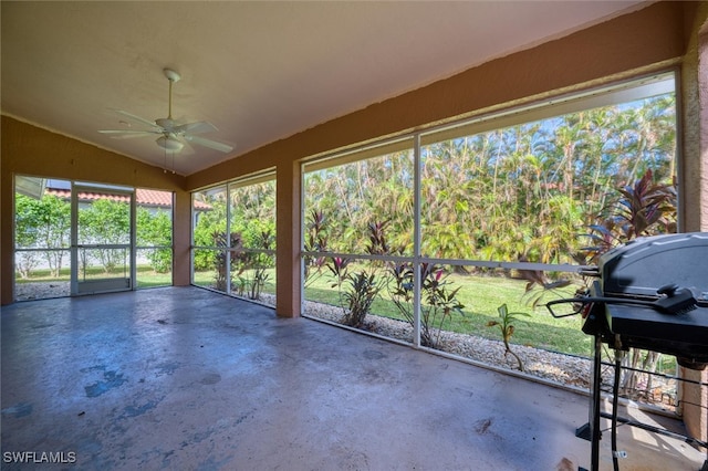 unfurnished sunroom with lofted ceiling, plenty of natural light, and ceiling fan