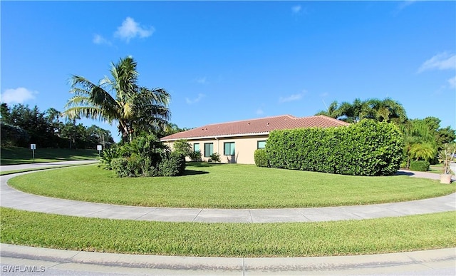 11599 Meadowrun Cir, Fort Myers, FL 33913 - view of side of property with a tiled roof, a lawn, and stucco siding
