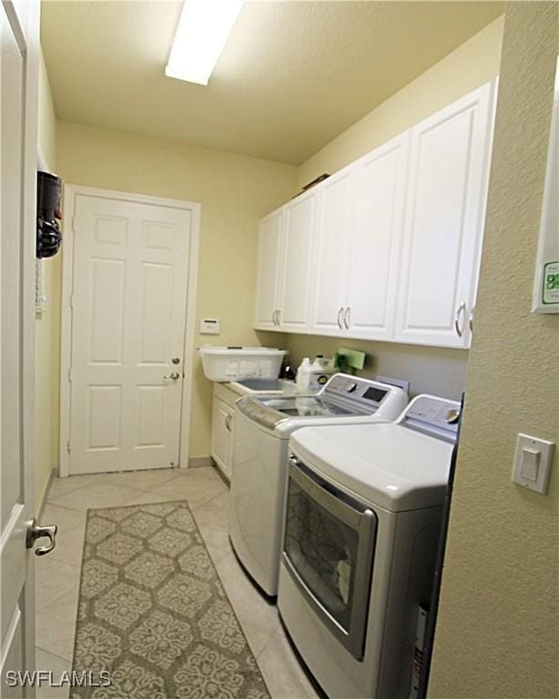 11599 Meadowrun Cir, Fort Myers, FL 33913 - washroom featuring cabinet space, washing machine and clothes dryer, and light tile patterned flooring
