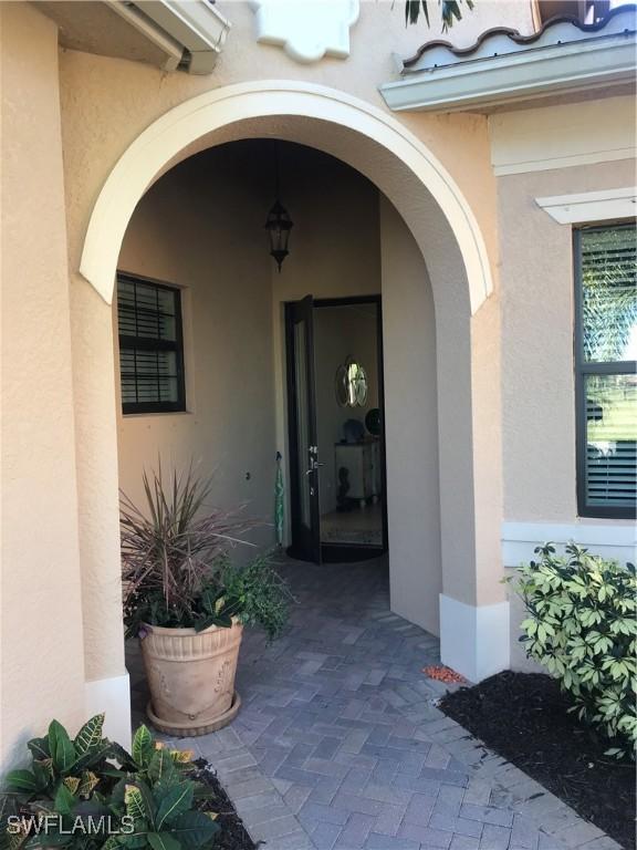 11599 Meadowrun Cir, Fort Myers, FL 33913 - view of exterior entry featuring stucco siding
