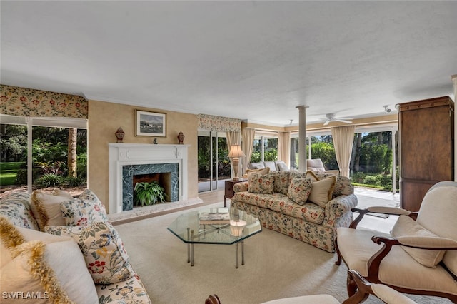 living room featuring a high end fireplace and ceiling fan