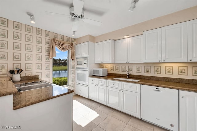 kitchen with a water view, white cabinets, white appliances, ceiling fan, and sink