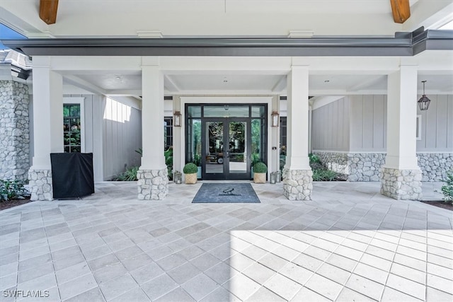 view of exterior entry with french doors and a patio area