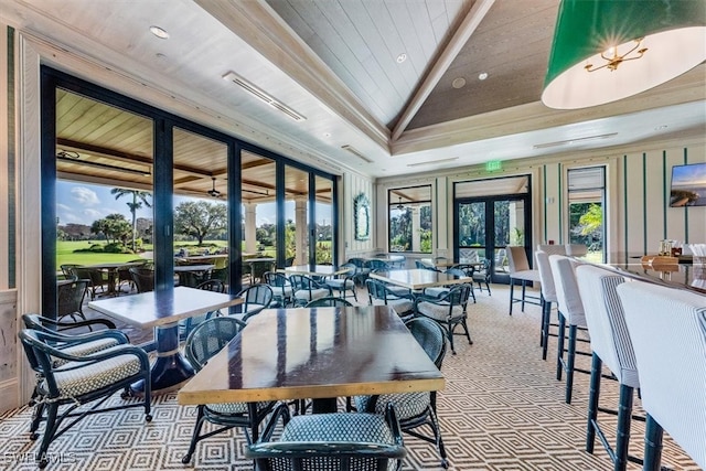 carpeted dining space with french doors and lofted ceiling