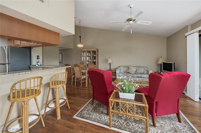 living room featuring dark hardwood / wood-style flooring, ceiling fan, and lofted ceiling