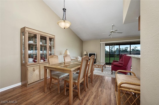 dining space featuring dark hardwood / wood-style floors, ceiling fan, and lofted ceiling