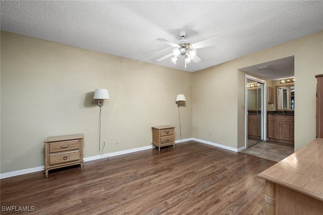 unfurnished room with ceiling fan, dark hardwood / wood-style flooring, a textured ceiling, and sink