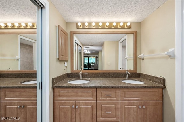 bathroom featuring a textured ceiling, vanity, and ceiling fan