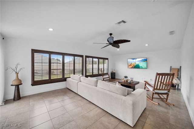 living room featuring visible vents, vaulted ceiling, and light tile patterned flooring