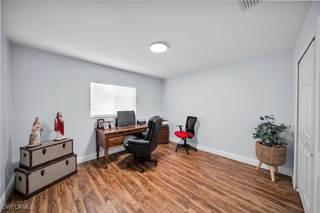 office featuring visible vents, baseboards, and wood finished floors