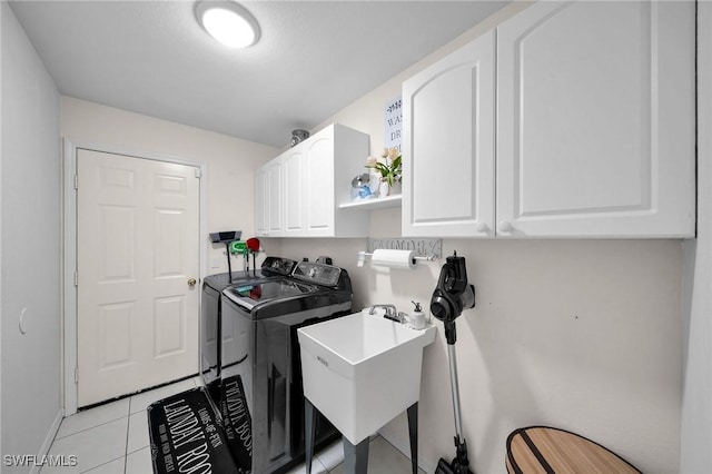 laundry room featuring cabinet space, washer and clothes dryer, a sink, and light tile patterned flooring