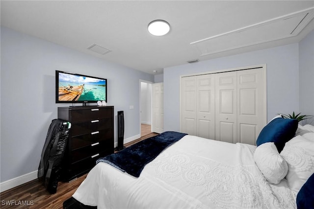 bedroom featuring attic access, visible vents, baseboards, dark wood-type flooring, and a closet