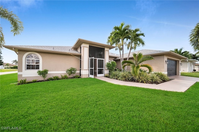 view of front of home featuring a garage, a sunroom, and a front lawn