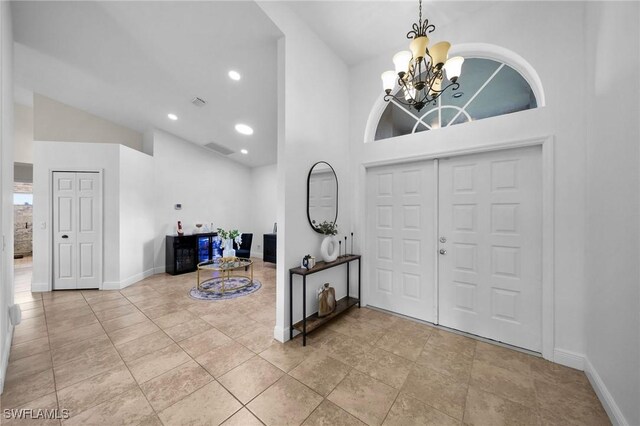 entryway with a towering ceiling and a chandelier