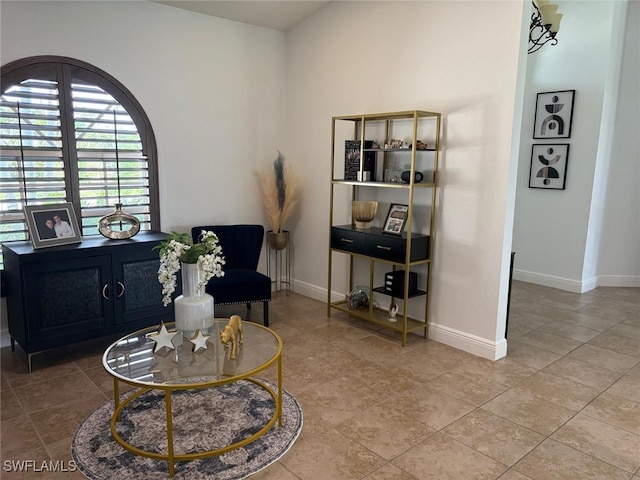 living area with baseboards and tile patterned floors