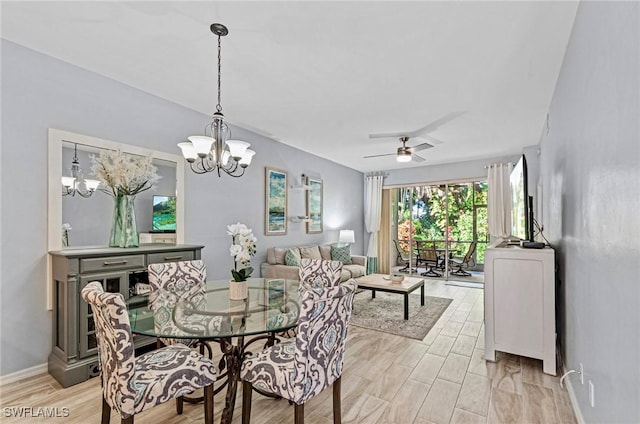 dining space with ceiling fan with notable chandelier and light hardwood / wood-style flooring