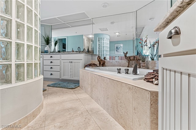 bathroom with vanity, a relaxing tiled tub, and tile patterned floors