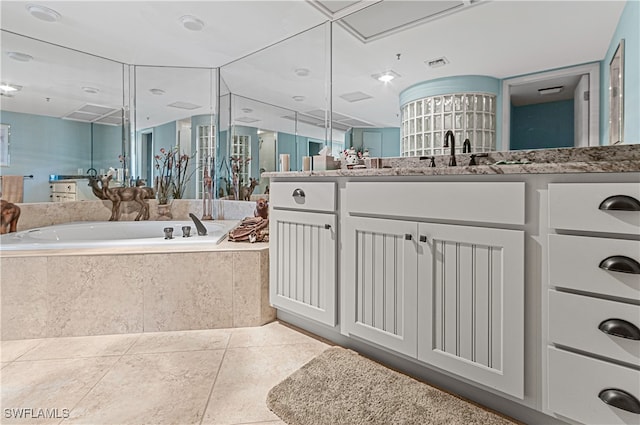 bathroom featuring vanity, tile patterned floors, and tiled tub