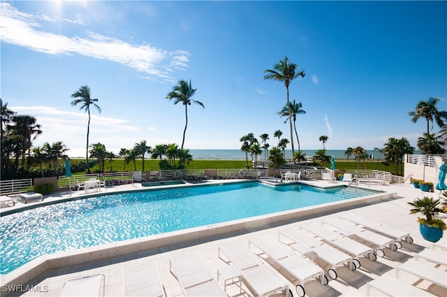 view of swimming pool featuring a patio area and a water view