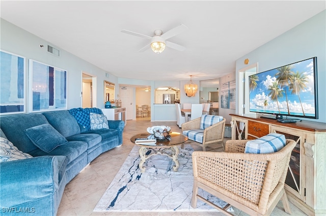 living room with light tile patterned flooring and ceiling fan with notable chandelier